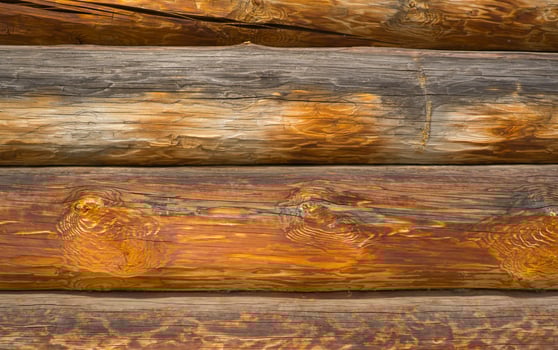 Wooden wall assembled from timber or logs. Background of horizontal logs. photo