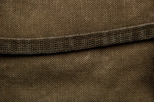 Close-up texture of a canvas fabric backpack. Leather straps and metal buckles. Vintage khaki back. photo