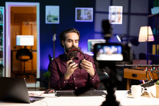 Content creator endorsing headphones for internet streaming platforms viewers, recording with professional camera. Tech expert promoting music listening device, filming with specialized gear photo