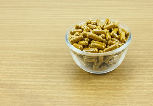 Turmeric capsule powder on wooden background photo