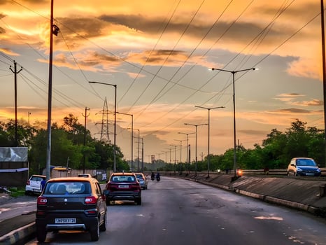 Cars driving on a road at sunset with power lines photo