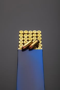 A box of cartridges for a pistol on a dark back. Ammunition for weapons. photo