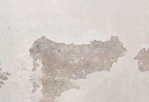 Weathered Wall Texture with Peeling Paint revealing the underlying concrete or plaster. The surface is uneven and shows signs of wear and tear, with cracks, chips, and exposed patches photo