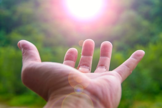 Hand reaching out a shining light representing blessing. Ideas for copy space for inspirational messages photo