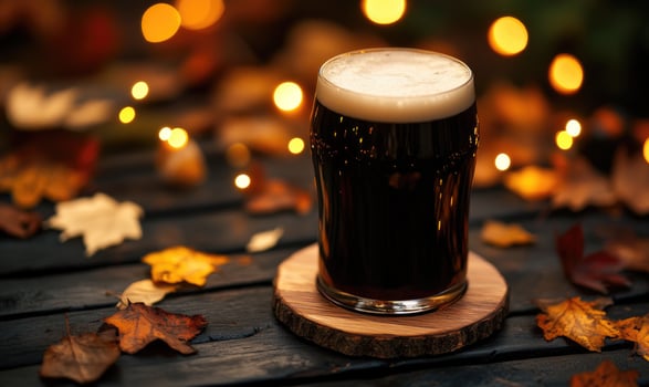 Pint of dark beer on wooden coaster, encircled by warm fairy lights photo