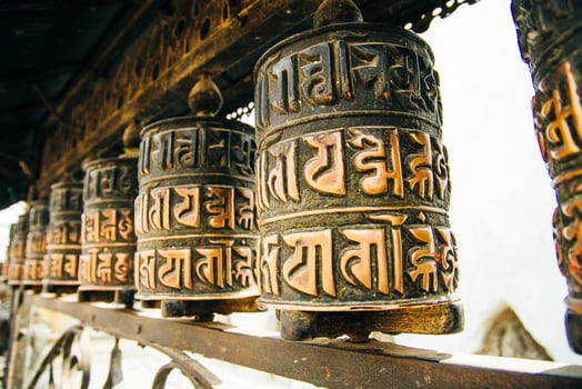 Prayer drum. Old prayer cylinders in Nepal. Tibetan Prayer wheels. Buddhist rolls in row photo