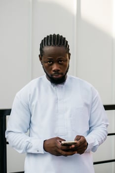 Millennial generation african american man typing sms outdoor 5g internet concept. High speed internet on phone and chatting on social networks and blog concept photo