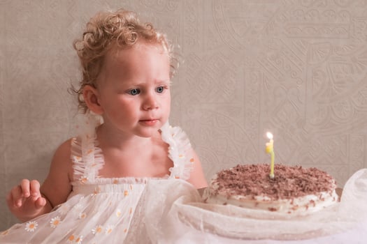 Baby girl celebrating her birthday with birthday cake photo