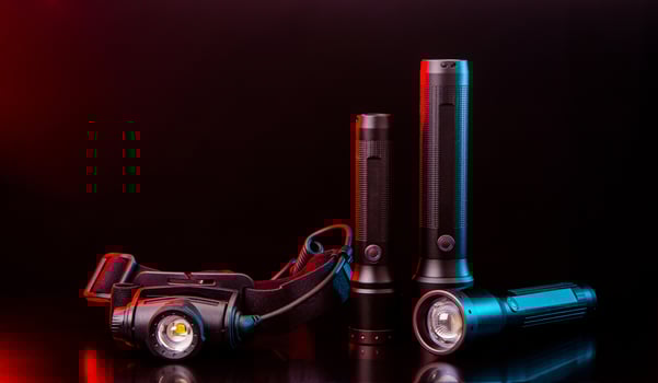 Head and pocket flashlights on a dark back. Modern lanterns illuminated with red-blue light. photo