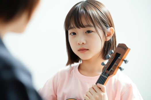 Young girl learning to play the ukulele photo