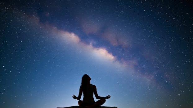 Silhouette of a woman meditating under a starry sky photo