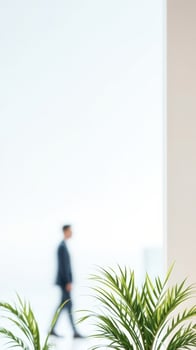 Blurred Businessman Walking Past a Green Plant in a Modern Office photo
