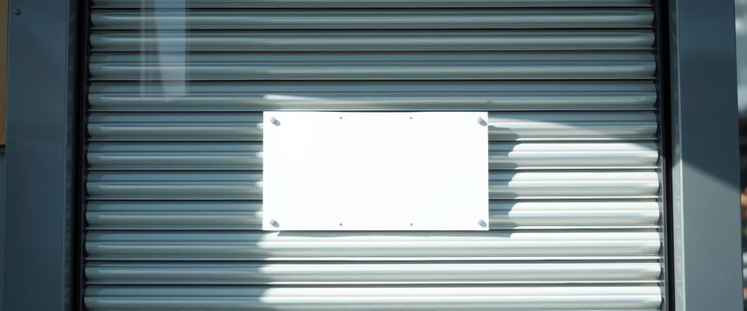 Blank White Sign on Metal Roll-Up Door photo