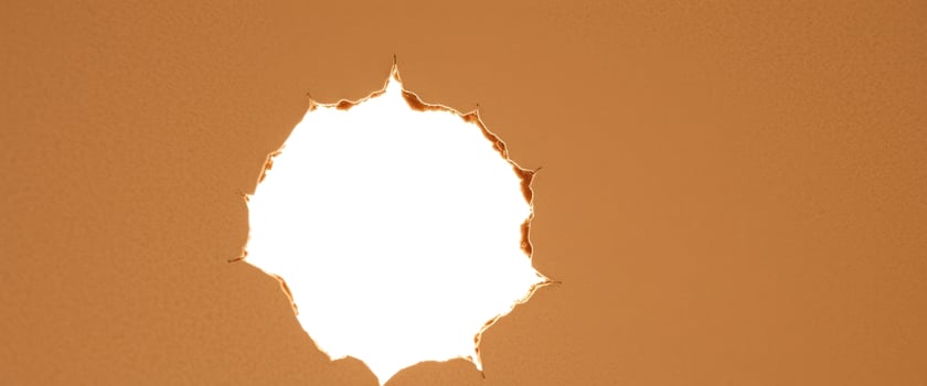 Torn brown paper with a hole in the center photo