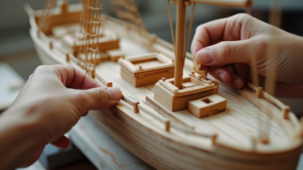 Closeup of Hands Assembling a Wooden Ship Model photo