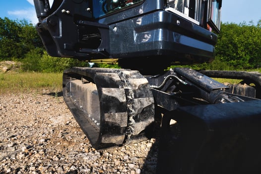 Bucket and rubber crawler tracks of a small excavator close-up photo
