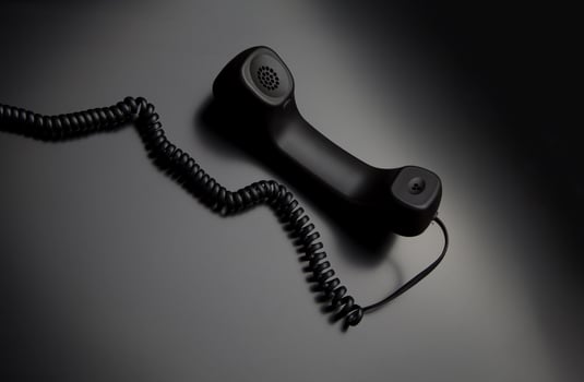 modern telephone receiver on dark back. concept technical support by phone. waiting for an answer. no answer. photo