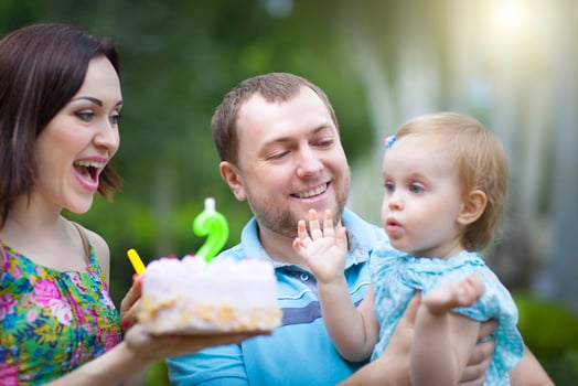 Happy family celebrating second birthday of baby daughter photo