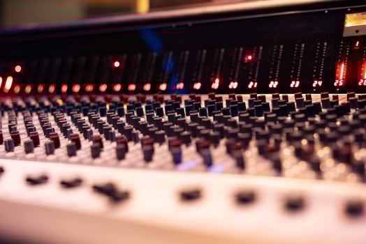 Mixing console and music production knobs in empty control room, technical gear used for recording and producing new tracks. Switchers, sliders and buttons editing audio files. Close up. photo