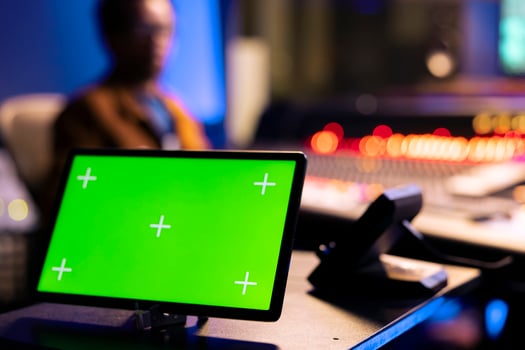 African american audio technician editing tracks next to isolated display on tablet, operating on control room panel board. Music engineer pushing faders and buttons in post production studio. photo