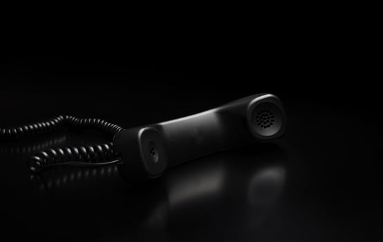 modern telephone receiver on dark back. concept technical support by phone. waiting for an answer. no answer. photo