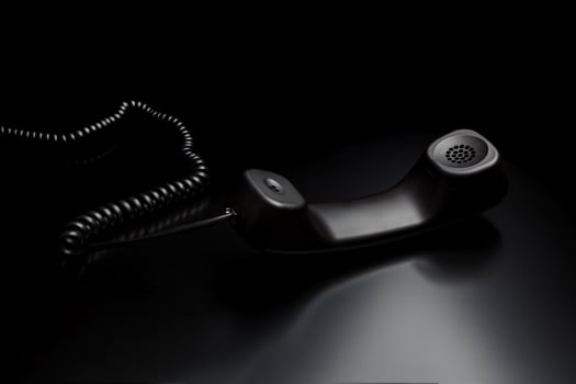 modern telephone receiver on dark back. concept technical support by phone. waiting for an answer. no answer. photo