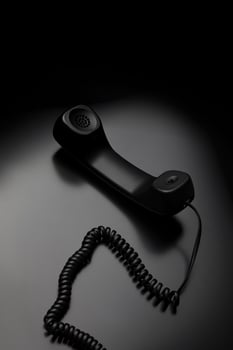 modern telephone receiver on dark back. concept technical support by phone. waiting for an answer. no answer. photo