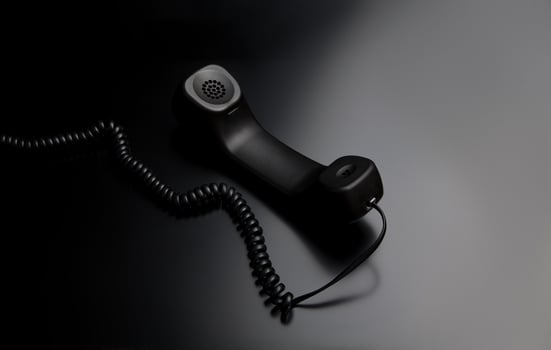 modern telephone receiver on dark back. concept technical support by phone. waiting for an answer. no answer. photo