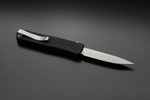 Penknife on a black gradient background. Modern folding knife. photo