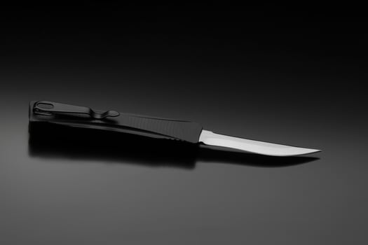 Penknife on a black gradient background. Modern folding knife. photo