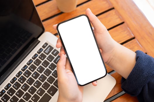 Top view image of a woman using her smartphone while working remotely at a cafe. photo