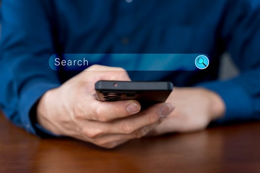Close-up of hand a man using a mobile phone search for information interest on search engine website photo