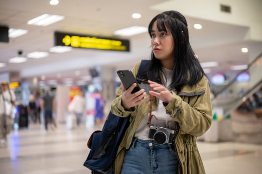 A female solo traveler or backpacker is walking in the airport, looking for her check-in counter. photo