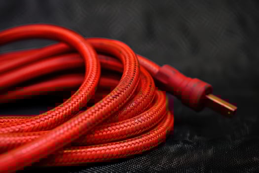 Close-up of a twisted red electrical extension cord on a dark background photo