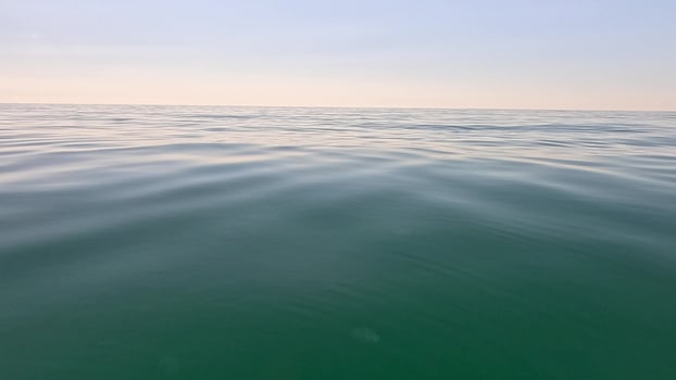 Sea water surface. Low angle view over clear azure sea water. Sun glare. Abstract nautical summer ocean nature. Holiday, vacation and travel concept. Nobody. Slow motion. Weather and climate change photo