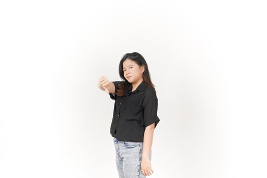 Young Asian woman showing thumbs down wearing Black t-shirt and jeans isolated on white background photo