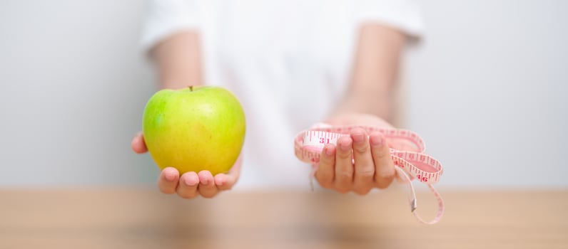 woman hand hold green Apple with tape measure, happy female choose fruit is Healthy food. Dieting control, Weight loss, Obesity, eating lifestyle and nutrition concepts photo