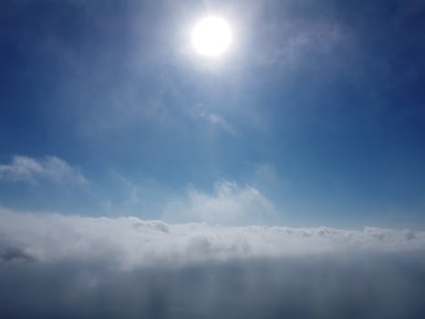 Aerial view. The drone flies over foggy and fluffy clouds. Blue sky sun and sea fog. Abstract aerial nature summer ocean sunset sea and sky background. Vacation, travel and holiday concept photo