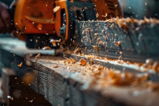 Woodworking in progress with saw cutting through timber, creating wood shavings indoors photo