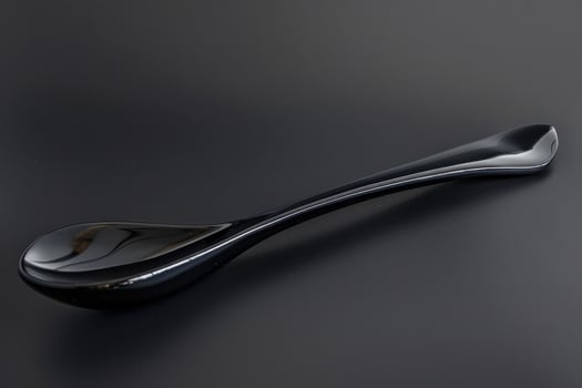Elegant black porcelain spoon on a dark surface photo