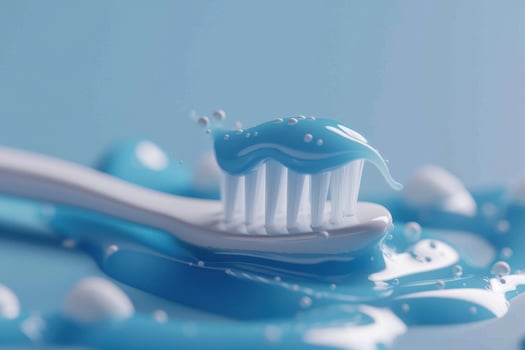 Close-up of a toothbrush with blue toothpaste on a light blue background, highlighting dental hygiene photo