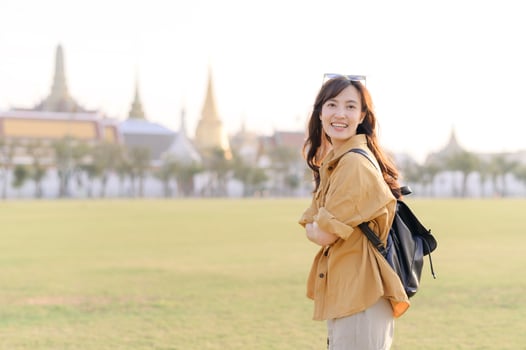 A Traveler Asian woman in her 30s exploring Wat Pra Kaew. From stunning architecture to friendly locals, she cherishes every moment, capturing it all in her heart and camera for years to come. photo