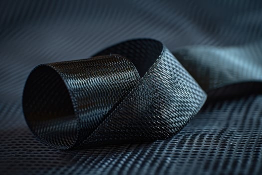 Detailed view of a black woven fabric roll on a textured background photo