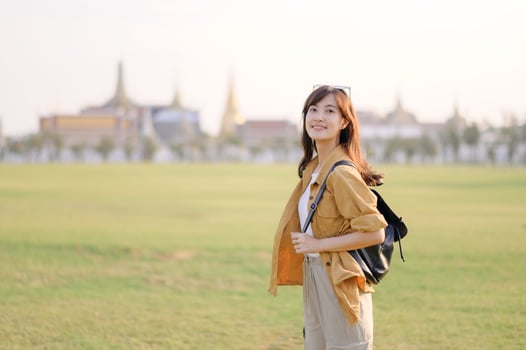 A Traveler Asian woman in her 30s exploring Wat Pra Kaew. From stunning architecture to friendly locals, she cherishes every moment, capturing it all in her heart and camera for years to come. photo