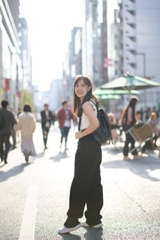 Embrace the energy of Tokyo, a young Japanese businesswoman with a positive outlook in the bustling urban scene. photo