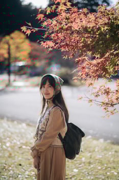 Casual dress elegance, Asian woman explores Kyoto's fall beauty, capturing cheerful smiles amid vibrant foliage and the scenic allure of Japanese tradition during a holiday. photo