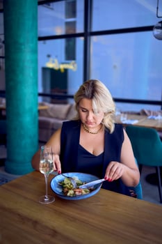a middle-aged plus size woman in old money style clothes in a fancy restaurant photo