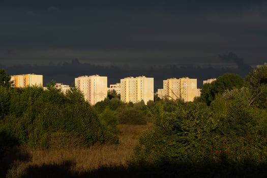 Residential, panel houses in the distance against the background of dark clouds photo