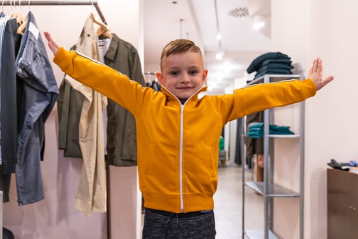 young child having fun posing as a model in a clothing store photo