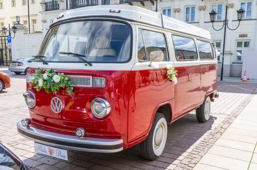 Newlyweds car. Red minibus volkswagen. Retro bus car. Decorated with bouquets of flowers. Festive decor, bridal bouquet. Just married. Poland, Warsaw - July 30, 2023 photo